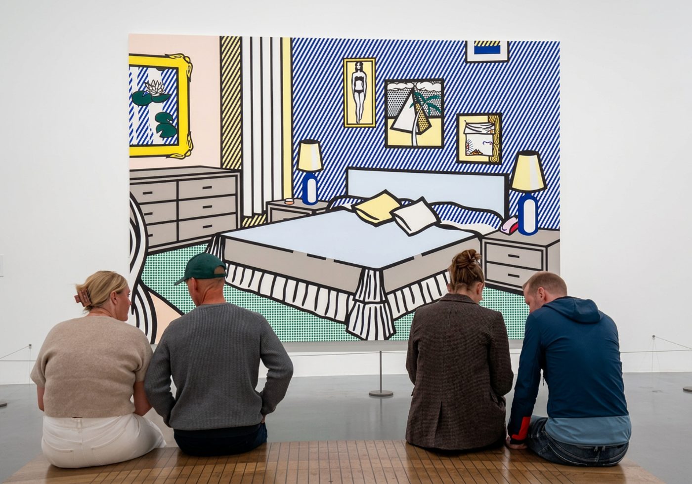 Four people sitting on a gallery bench in front of a huge Roy Lichtenstein bedroom painting, all looking down or at each other rather than at the art.